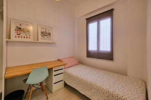 a bedroom with a bed and a desk and a window at Mossen flat Patraix in Valencia