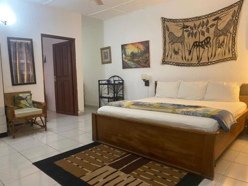 1 dormitorio con 1 cama con una foto en la pared en Casablanca Guest Inn, en Takoradi