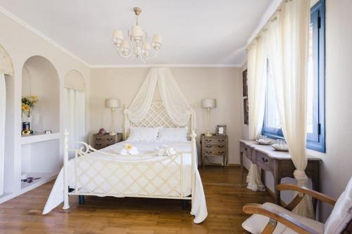 um quarto com uma cama branca e um lustre em Casa di campagna em Faskomiliá