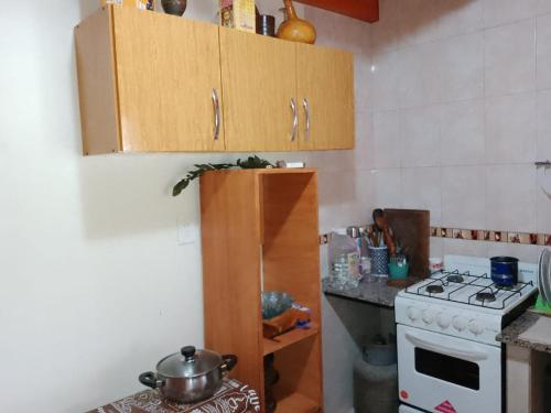 a small kitchen with a stove and a counter top at Cabaña El Abuelo in San Pedro de Colalao