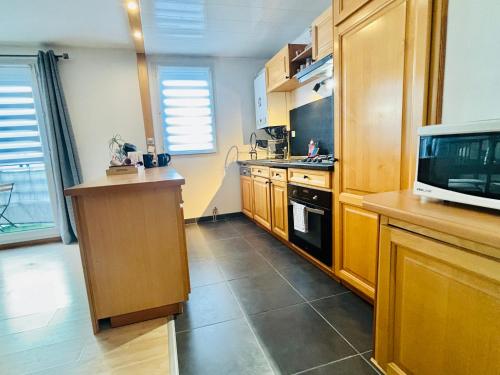 a kitchen with wooden cabinets and a microwave at Beautiful Apartment Disneyland in Saint-Thibault-des-Vignes