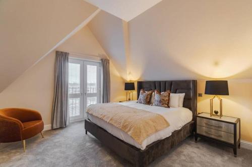a bedroom with a large bed and a window at Luxury Penthouse - Castle Views - 2 Bed & Parking in Windsor