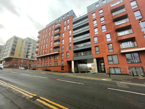 an empty street in front of a brick building at Adelphi Wharf Apartments by Beehosting in Manchester