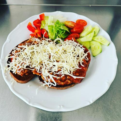 a white plate with a sandwich with cheese and vegetables at Kavárna a penzion REICHL in Králíky
