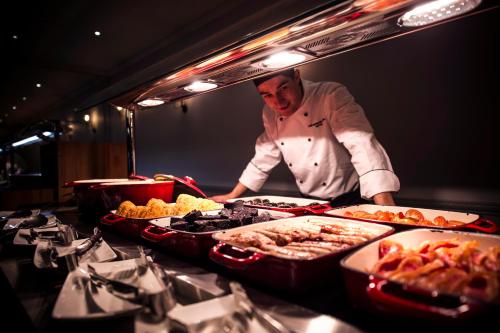 a chef standing in front of a buffet of food at DoubleTree by Hilton Cheltenham-Cotswolds in Cheltenham
