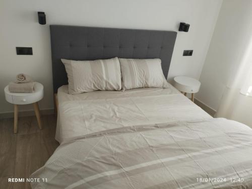 ein Schlafzimmer mit einem großen Bett mit einem grauen Kopfteil in der Unterkunft ESTUDIO d'PACO in Callosa d'en Sarrià