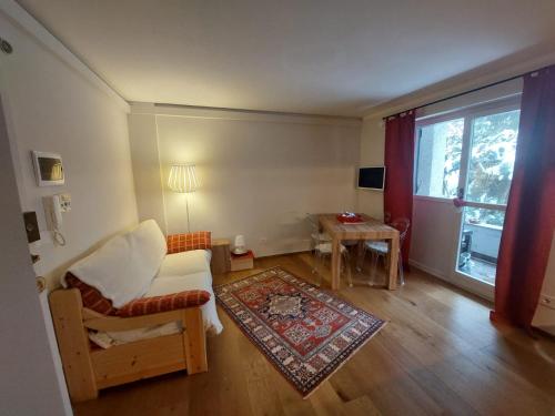 - un salon avec un canapé, une chaise et une fenêtre dans l'établissement Sauze Apartment, à Sauze dʼOulx