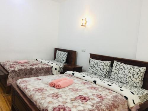 1 dormitorio con 2 camas y almohadas rosas en Highest Village Bungalow, en Nuwara Eliya