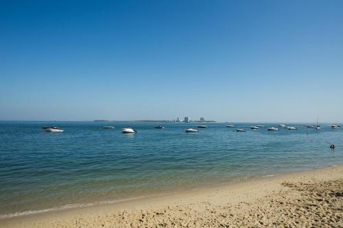 a group of boats in the water on a beach at Hotel Solaris in Setúbal