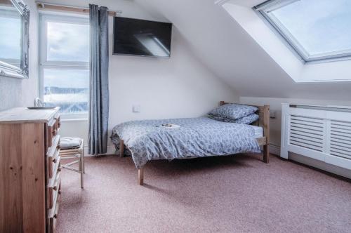 a bedroom with a bed and a window at Fulke Street - 2 Bedroom Apartment - Milford Haven in Milford Haven