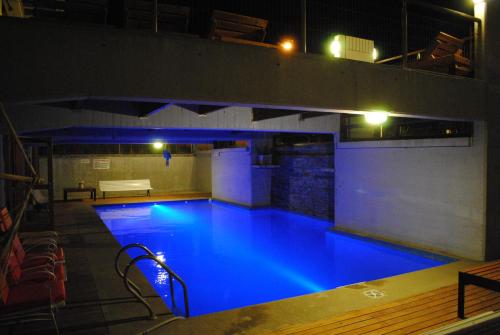 a large swimming pool at night with blue illumination at Complejo Sakura in Villa Gesell