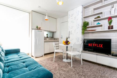 聖保羅的住宿－Condomínio VN，一间带蓝色沙发的客厅和一间厨房