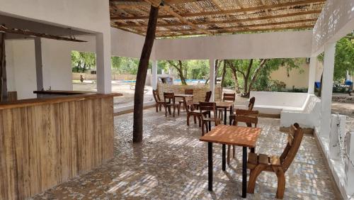 een patio met tafels en stoelen en een bar bij Les Fromagers in Missira