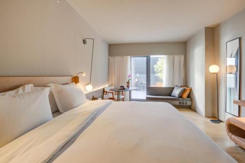 Cette chambre comprend un grand lit blanc et une fenêtre. dans l'établissement DoubleTree by Hilton Porto Alegre, à Porto Alegre