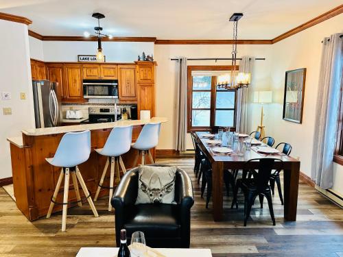 a dining room with a table and a kitchen at Le Plateau by Tremblant Vacations in Mont-Tremblant