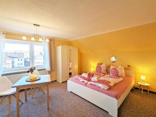 a bedroom with a bed and a table and a window at Urlaubsmagie - Ferienwohnung Libelle - direkt am Wanderweg - L5 in Sebnitz