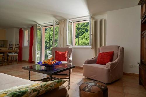 een woonkamer met 2 stoelen en een tafel bij Wild Valley Forest View 3 in Valle Onsernone in Vergeletto