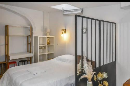 - une chambre avec un lit blanc et une étagère dans l'établissement Au cœur d'AVIGNON 2 - WIFI - CENTRE VILLE, à Avignon