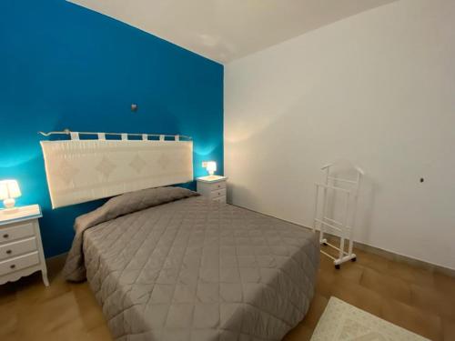 ein Schlafzimmer mit einem Bett und einer blauen Wand in der Unterkunft CASA PAESE SPIAGGIA VIA MONTI in San Teodoro