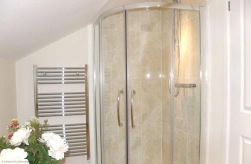 a shower with a glass door in a bathroom at Maplescombe in Alton