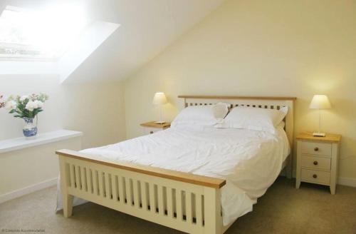 a bedroom with a large white bed with two night stands at Maplescombe in Alton