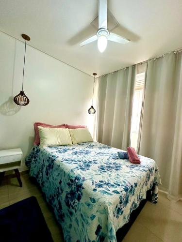 Schlafzimmer mit einem Bett und einem Deckenventilator in der Unterkunft Biquinha - Praça 22 de Janeiro in São Vicente