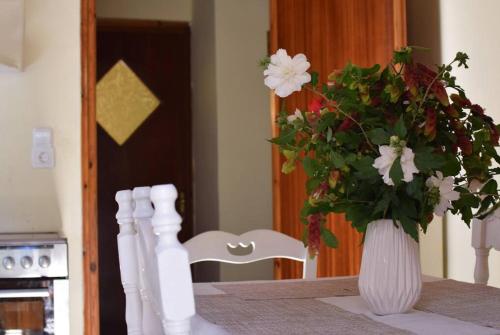 un vase de fleurs assis sur une table à côté d'un vase dans l'établissement Kiki’s Beautiful House On Famous Village Pentati, à Pentátion