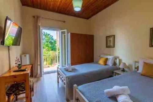 - une chambre avec 2 lits et une fenêtre dans l'établissement Kiki’s Beautiful House On Famous Village Pentati, à Pentátion