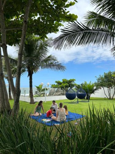 a group of people sitting on a blanket in a park at Casa Cancun Hotel Boutique & Eventos in Penha