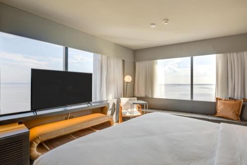 a hotel room with a large bed and a flat screen tv at DoubleTree by Hilton Porto Alegre in Porto Alegre
