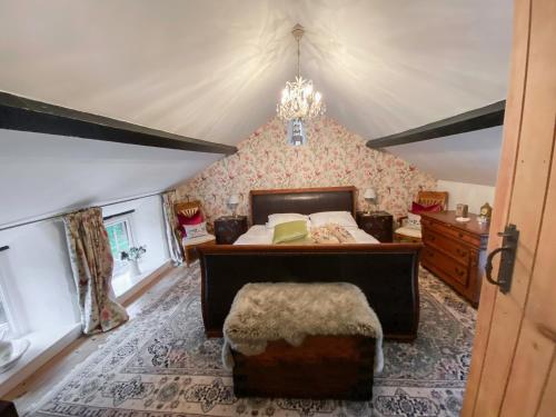 1 dormitorio con cama y lámpara de araña en Swallow Cottage - A Cosy Retreat Near Snowdonia and the Coast en Abergele