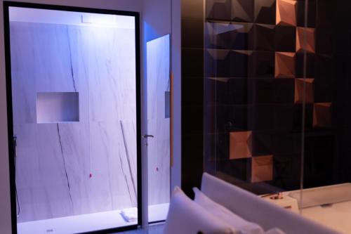 um quarto com uma porta de vidro e um espelho em Kreart Suite & Rooms B&B em Crotone