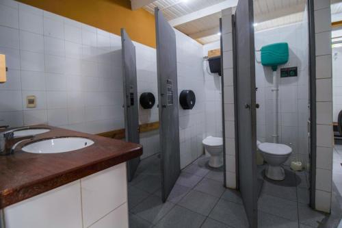 a bathroom with a sink and two toilets at Mundaka Hostel y Bar in Punta del Este