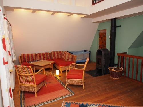 a living room with a couch and chairs and a wood stove at Der Fuchsbau in Meesiger