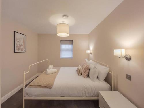 a bedroom with a bed with white sheets and pillows at Escape in Style to Windsor with Free Parking in Windsor
