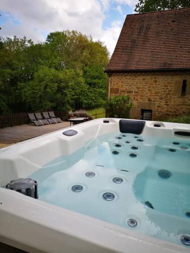une baignoire jacuzzi dans l'arrière-cour d'une maison dans l'établissement Maison climatisée avec jacuzzi à 10 min de Sarlat, à Sarlat-la-Canéda