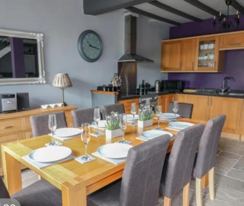a dining room with a wooden table and chairs at Lovely 4 bed house sleeping 8 near Ashbourne in Brassington