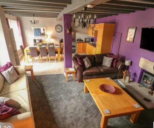 a living room with a couch and a table at 4 Bed Sleeps 8 On-Road Parking WiFi in Brassington