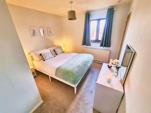 a small bedroom with a bed and a mirror at Bluebirds Cottage - Light & Airy 2 Bed in Bourton! in Bourton on the Water