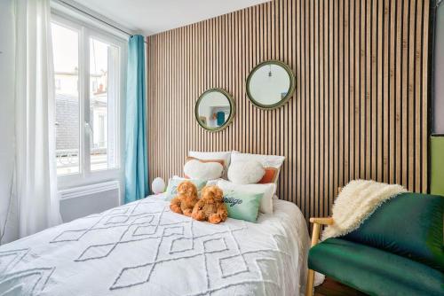 a bedroom with a bed with two teddy bears on it at Fabuleux Paris/ Stade de france in Saint-Denis