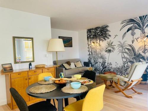 un salon avec une table et des chaises dans l'établissement Vue mer à La Baule : Le Victor Hugo, à La Baule