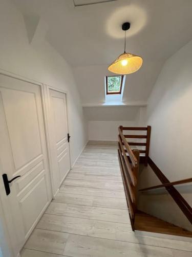 a hallway with a white door and a wooden bench at Charmante maison en Brenne in Vendoeuvres