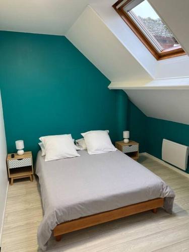 a bedroom with a large bed with a blue wall at Charmante maison en Brenne in Vendoeuvres