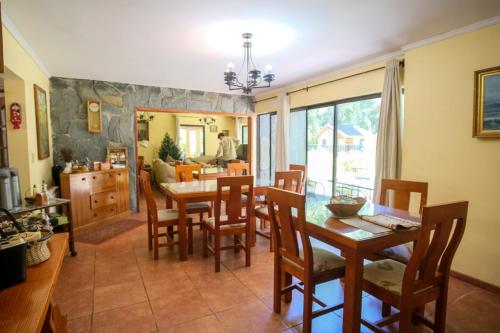 eine Küche und ein Esszimmer mit einem Tisch und Stühlen in der Unterkunft Casa de Noah Bed & Breakfast in Pucón