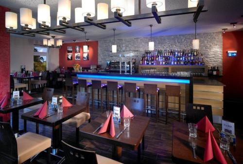 a restaurant with tables and chairs and a bar at Hotel La Baia in Cochem