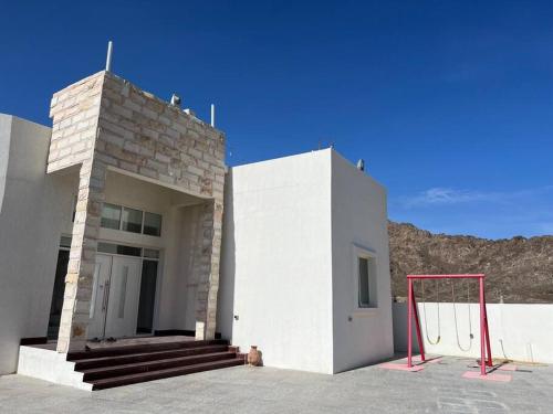 a building with a basketball hoop in front of it at Masfout/hatta mountain villa in Sinādil