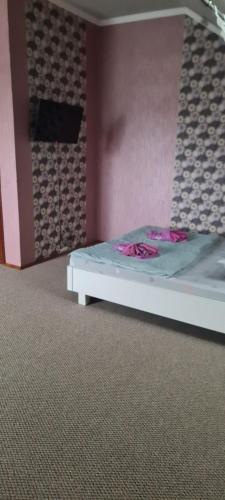 - un lit dans une chambre avec un mur rose dans l'établissement Inn Alibi, à Khorodelets