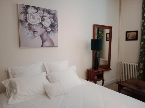 ein Schlafzimmer mit einem weißen Bett mit einem Bild an der Wand in der Unterkunft Domaine de Pladuc in Lachaise