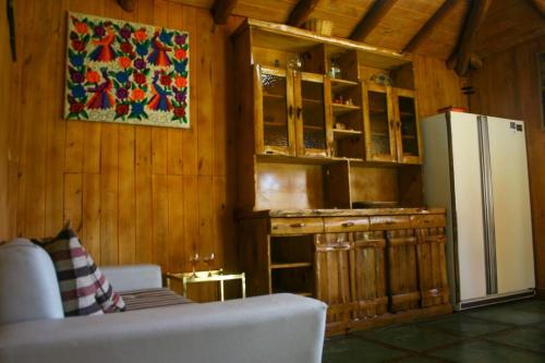 a kitchen with a refrigerator and a couch in a room at Costa del azul in Los Repollos