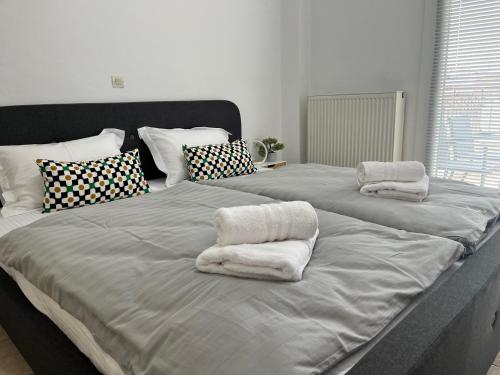 2 Betten mit Handtüchern in einem Schlafzimmer in der Unterkunft MaVitaPlace Harmonia Apartment in Kateríni